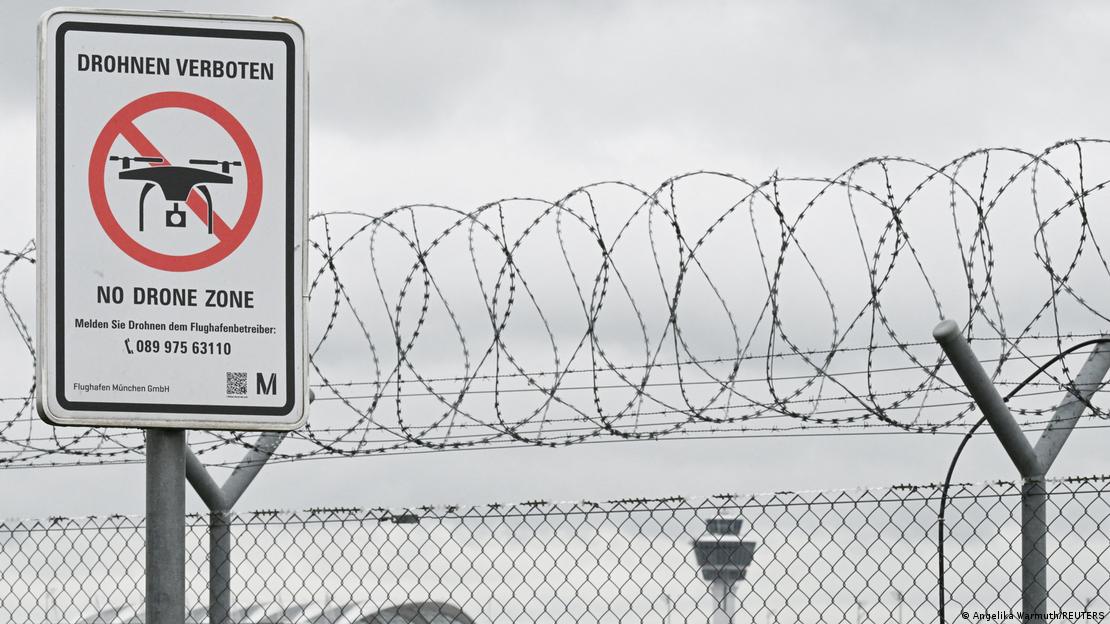 Münih havalimanında tel örgülerin önünde duran "İHA'lar yasak" yazılı levha.
