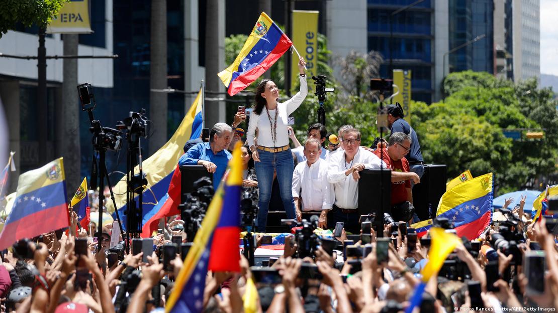 Maria Corina Machado y sus seguidores, con banderas venezolanas.