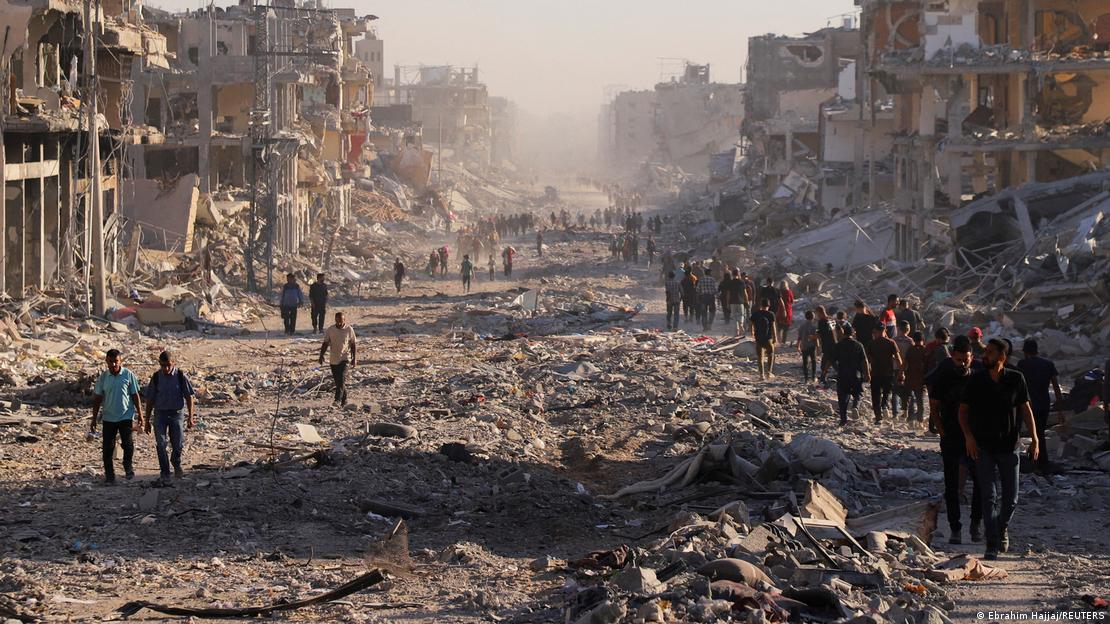 İsrail saldırılarında enkaza dönüşen Gazze sokaklarında yürüyen Filistinliler.