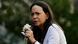 María Corina Machado en una protesta con un micrófono y una flor blanca en la mano. María Corina Machado en una protesta con un micrófono y una flor blanca en la mano.