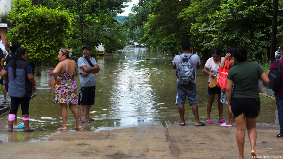 La gente observa una calle inundada tras las lluvias torrenciales que provocaron el desbordamiento de los ríos en Poza Rica, estado de Veracruz. La gente observa una calle inundada tras las lluvias torrenciales que provocaron el desbordamiento de los ríos en Poza Rica, estado de Veracruz.
