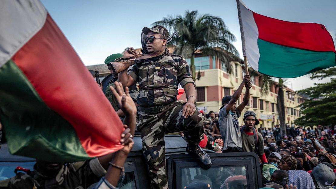 Başkent Antananarivo'da askerî araç üzerindeki bir Madagaskar askeri, protestocuların toplandığı meydandaki göstericilerin arasında. Askerî aracı coşkuyla karşılayan göstericilerden bazılarının ellerinde Madagaskar bayrakları var