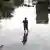 México, Poza Rica, 2025 | Hombre camina por una calle inundada tras lluvias torrenciales.
