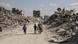Territorios Palestinos, Jan Yunis, 2025 | Un adulto y dos menores regresan a la ciudad destruida, por un camino, con montañas de escombros a ambos lados.