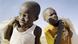 Still from the film 'Khartoum': Two children carrying bags. Still from the film 'Khartoum': Two children carrying bags.