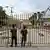 Cambodian police officials stand next to the closed gate at Poipet International border checkpoint between Cambodia-Thailand, at Poipet town in Banteay Meanchey province on June 24, 2025.
