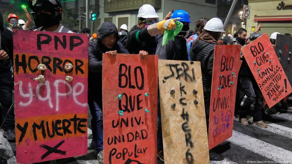 Los manifestantes se refugian de la policía tras carteles que les sirven de escudos durante una protesta contra el nuevo presidente José Jeri, en Lima, Perú, el miércoles 15 de octubre de 2025. Los manifestantes se refugian de la policía tras carteles que les sirven de escudos durante una protesta contra el nuevo presidente José Jeri, en Lima, Perú, el miércoles 15 de octubre de 2025.
