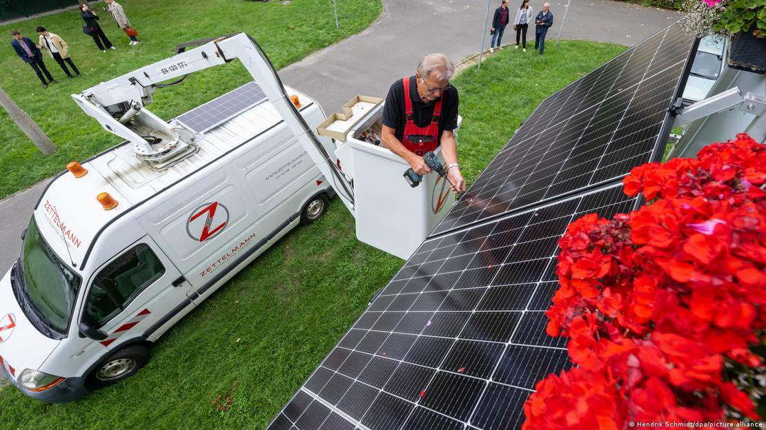 Bir balkona güneş paneli montajı yapan işçi