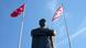 The Turkish flag is seen next to the Northern Cyprus flag, both next to a statue of Mustafa Kemal Atatürk The Turkish flag is seen next to the Northern Cyprus flag, both next to a statue of Mustafa Kemal Atatürk