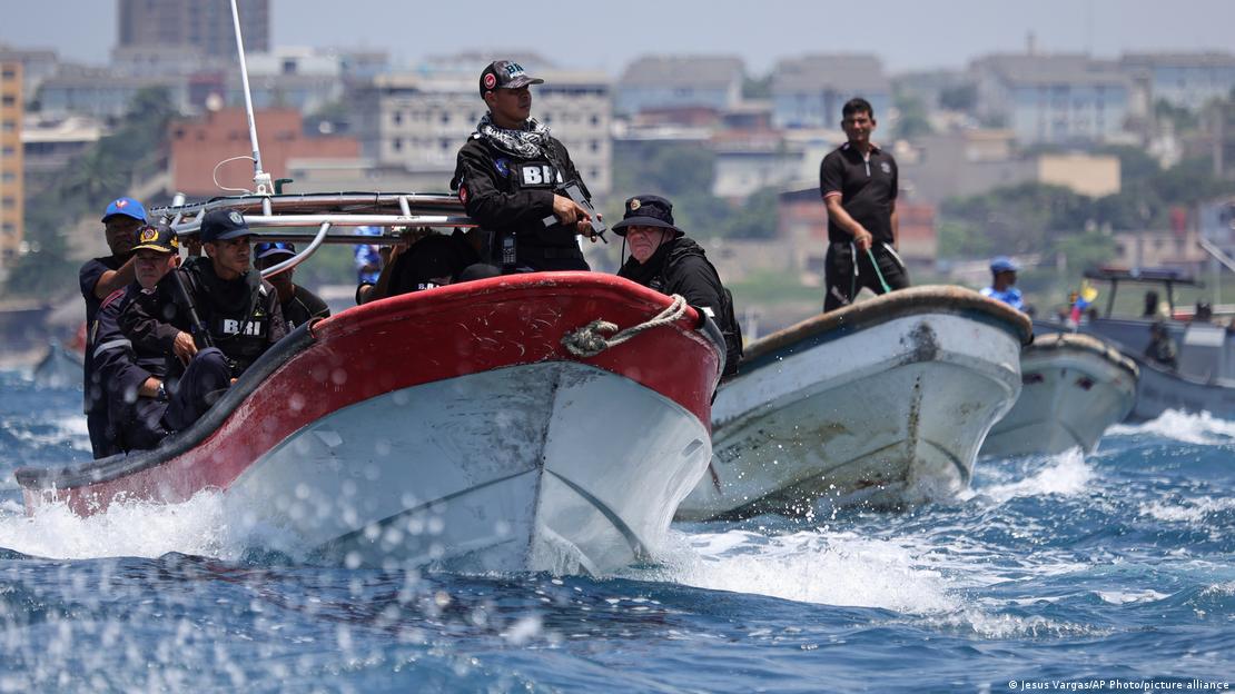 Venezuela La Guaira 2025 | Polizeibeamte bei stehen mit gezogenen Waffen auf fahrenden Booten Venezuela La Guaira 2025 | Polizeibeamte bei stehen mit gezogenen Waffen auf fahrenden Booten