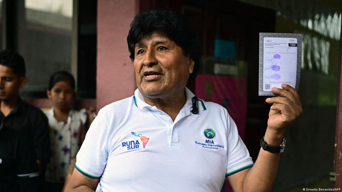 Evo Morales levanta uma das mãos, segurando cédula de votação