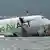 A cargo plane lies partially in the sea after veering off the runway during landing at Hong Kong International Airport on Oct 20, 2025