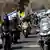Motorizados portan banderas israelíes cerca de la entrada del kibutz Nir Oz durante el funeral de Ronen Engel, un rehén que, según el ejército israelí, murió mientras defendía a su familia durante el ataque de Hamás el 7 de octubre de 2023. (21.10.2025)