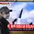 A man walks past a television screen showing a news broadcast with file footage of a North Korean missile test, at a train station in Seoul