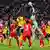 Bayern Munich and Borussia Dortmund players compete for a high ball, which is punched by Manuel Neuer