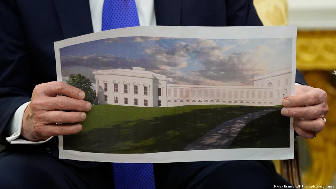 Trump'ın elinde Balo Salonu'nun inşası bittikten sonraki dış görünümünü yansıtan proje resmi. Trump'ın elinde Balo Salonu'nun inşası bittikten sonraki dış görünümünü yansıtan proje resmi.