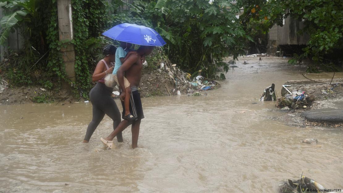 Un grupo de personas camina por una calle inundada en medio de la lluvia causada por la tormenta tropical Melissa, en Santo Domingo, República Dominicana, donde varias provincias se encuentra bajo alerta roja.