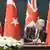 Keir Starmer ve Recep Tayyip Erdoğan, masada Eurofighter anlaşmasını imzalarken görülüyor. Arkalarında Türk ve Birleşik Krallık bayrakları var.