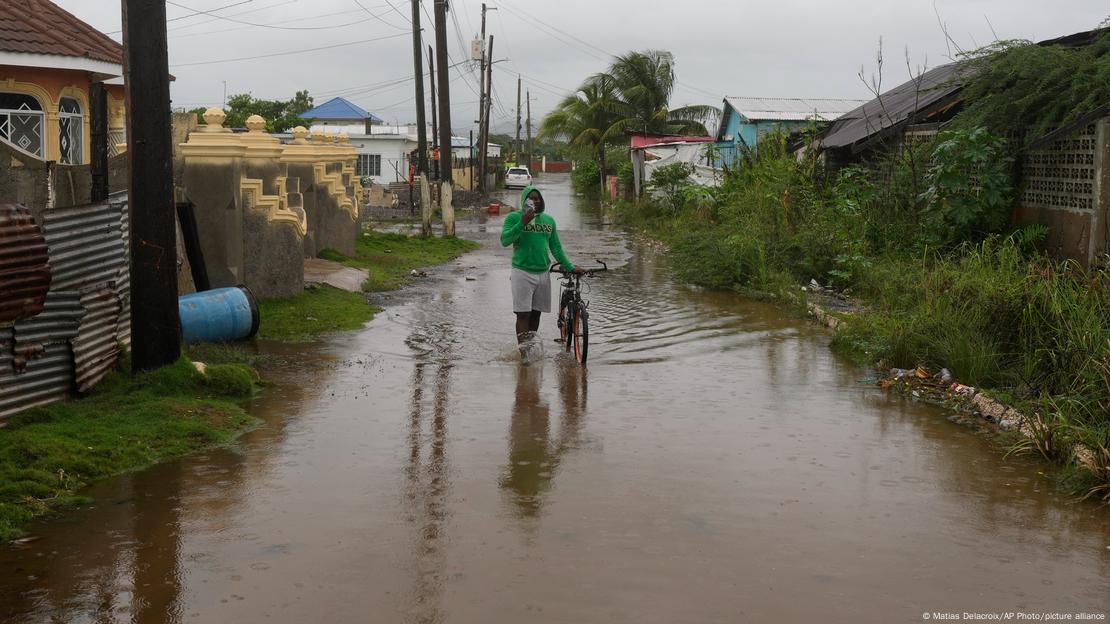 Una persona camina por una calle inundada por fuertes lluvias en Jamaica, antes de la llegada del huracán Melissa. Una persona camina por una calle inundada por fuertes lluvias en Jamaica, antes de la llegada del huracán Melissa.