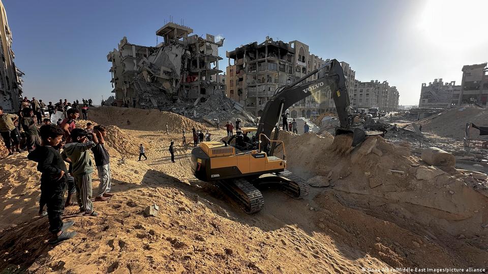 Una excavadora en Gaza opera en la exhumación de restos de un rehén israelí de Hamás. Detrás, edificios devastados por bombardeos del Ejército de Israel. (26.10.2025).