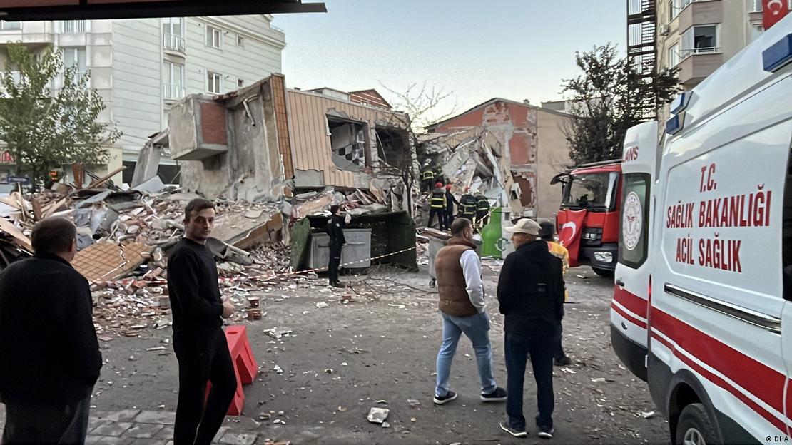 Gebze çöken binanın enkazı, önünde bekleyenler ile bir ambulans yandan görülüyor