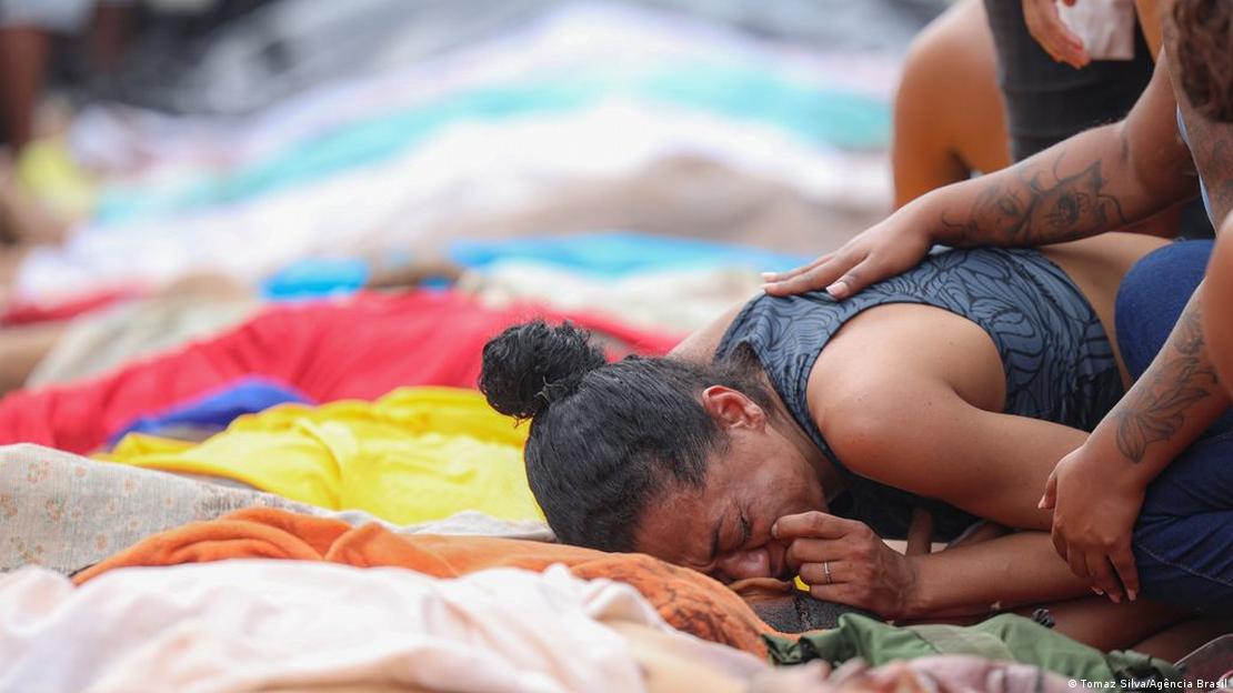 Mulher chora sobre silhueta de corpo enfileirado junto a dezenas de mortos na Praça São Lucas, no norte do Rio de Janeiro Mulher chora sobre silhueta de corpo enfileirado junto a dezenas de mortos na Praça São Lucas, no norte do Rio de Janeiro