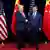 Donald Trump e Xi Jinping em aperto de mão, junto a bandeiras dos dois países