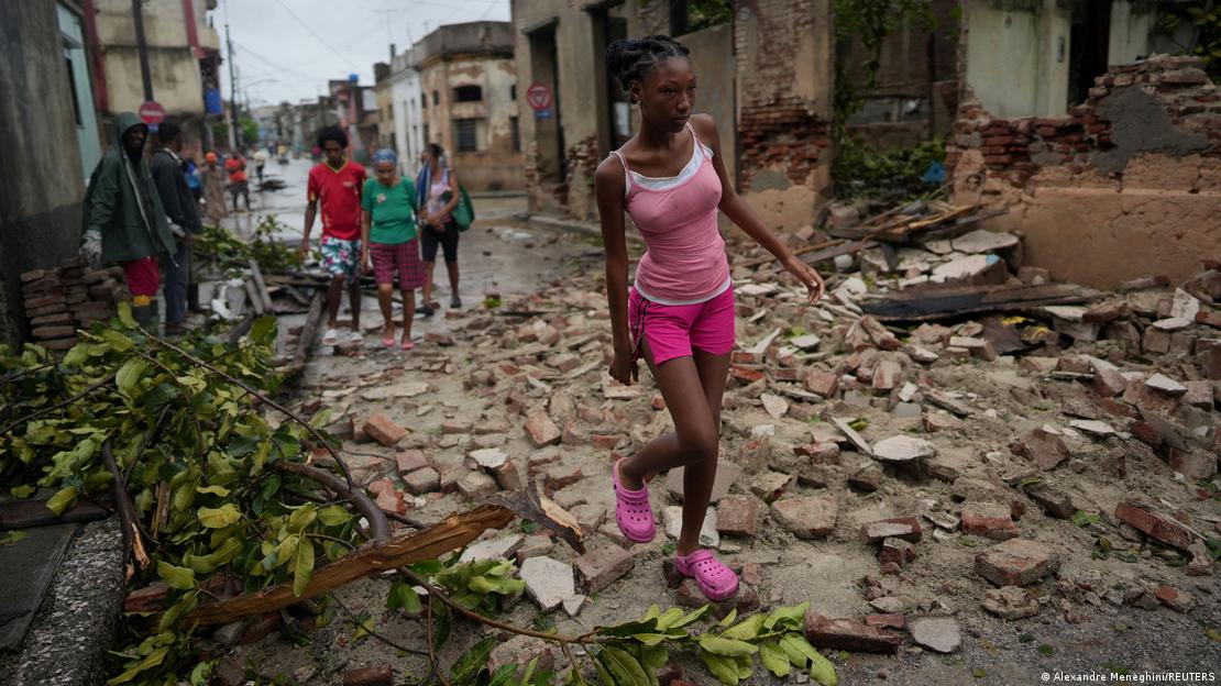 Residentes de Santiago, Cuba, caminan por los escombros y daños causados por el Huracán Melissa en 2025.
