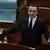 Ein Mann, der geschäftsführende Premierminister Kosovos, Albin Kurti, steht am Rednerpult des Parlaments und spricht mit weit ausgebreiteten Armen