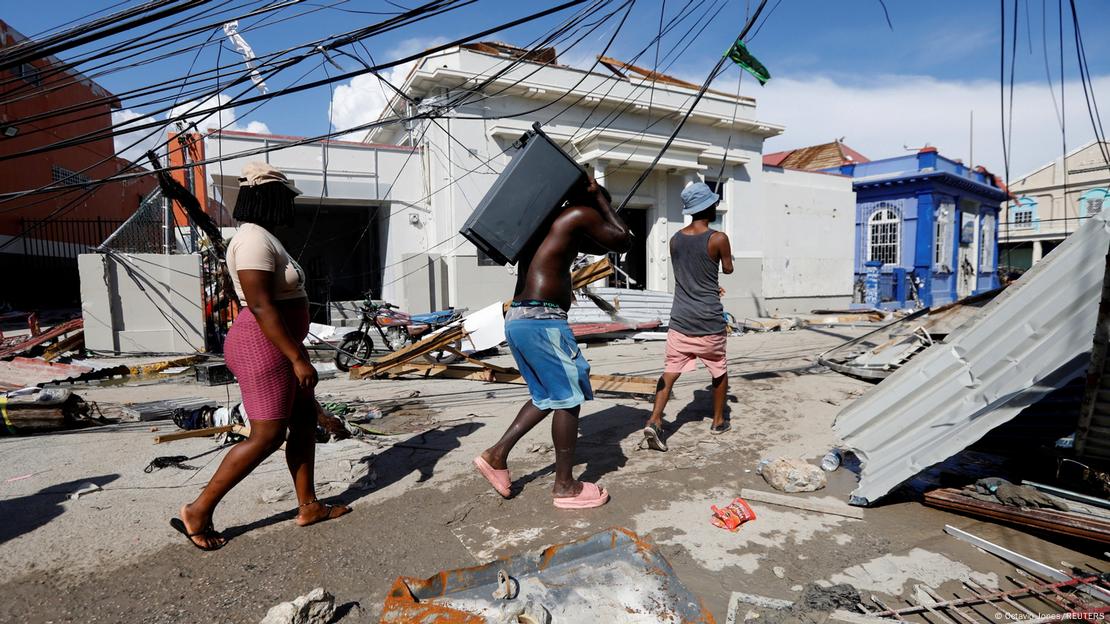 Un grupo de personas camina entre los escombros tras el paso del huracán Melissa en Black River, Jamaica.