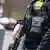 Close up of an officer wearsing a police vest and carrying a gun