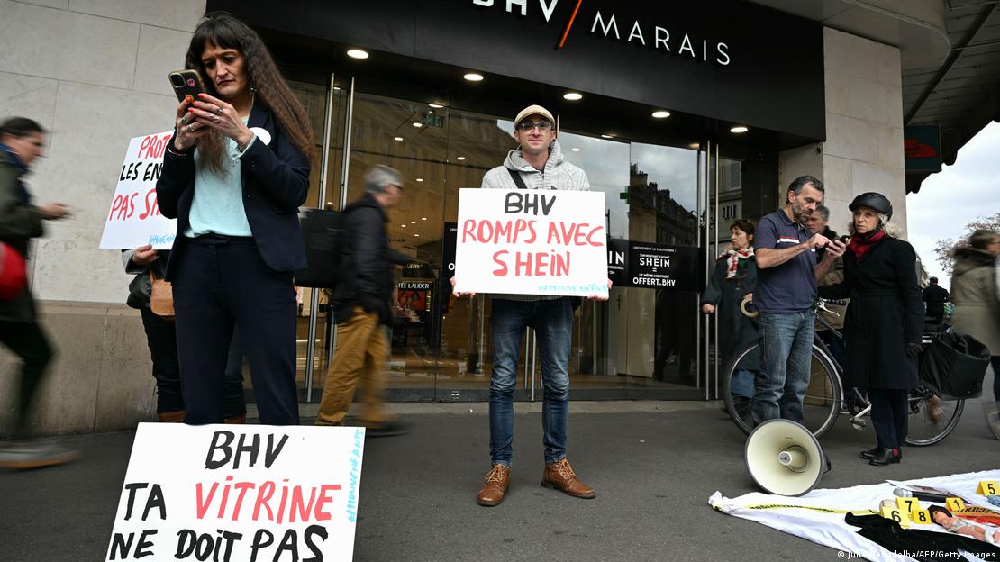 Manifestantes com cartazes protestam em frente a loja física da Shein em Paris Manifestantes com cartazes protestam em frente a loja física da Shein em Paris