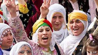 Kurdish women make V-victory signs as they chant slogans during a demonstration in Istanbul