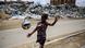 A Palestinian boy is playing next to piles of garbage amid the ongoing conflict in Gaza between Israel and Hamas in Deir Al-Balah, in the central Gaza Strip, on May 6, 2024. A Palestinian boy is playing next to piles of garbage amid the ongoing conflict in Gaza between Israel and Hamas in Deir Al-Balah, in the central Gaza Strip, on May 6, 2024.