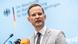 Germany's Drug Commissioner Hendrik Streeck, a young man in a suit and tie, speaking into several microphones at a press conference