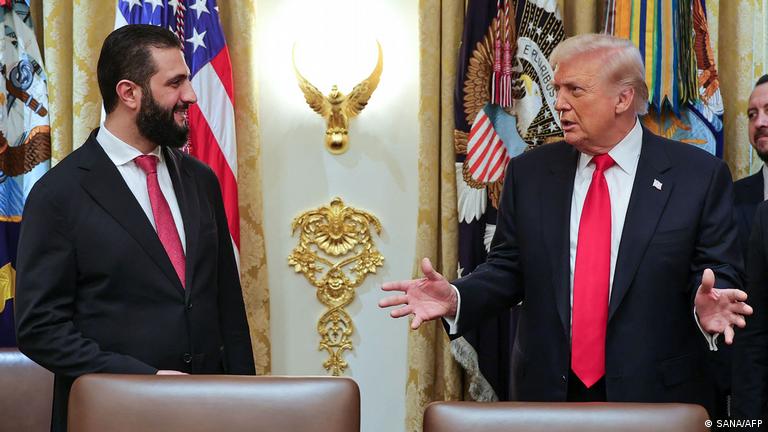 Suriye'nin geçici Devlet Başkanı Ahmed Şara ve ABD Başkanı Donald Trump geçen Kasım ayında Beyaz Saray'da, karşılıklı sohbet ediyor gibi görünüyorlar. Şara gülümseyerek Trump'a bakıyor 