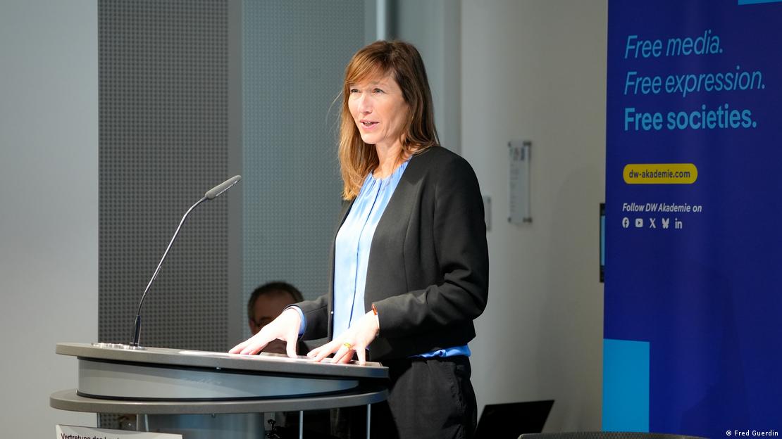 Massing habla desde el atril durante una presentación de DW Akademie. Detrás se puede leer, en inglés: "medios libres, libertad de expresión, sociedades libres".