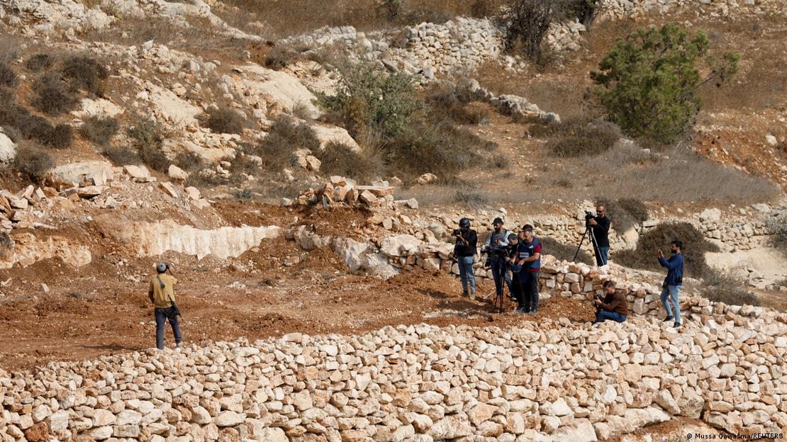 İsrail işgali altındaki Batı Şeria’nın Hebron kenti yakınlarında, İsrailli yerleşimcilerin topraklarına el koymasını protesto eden Filistinlileri görüntüleyen medya mensupları, silahlı bir İsrailli yerleşimcinin fotoğraflarını çekiyor