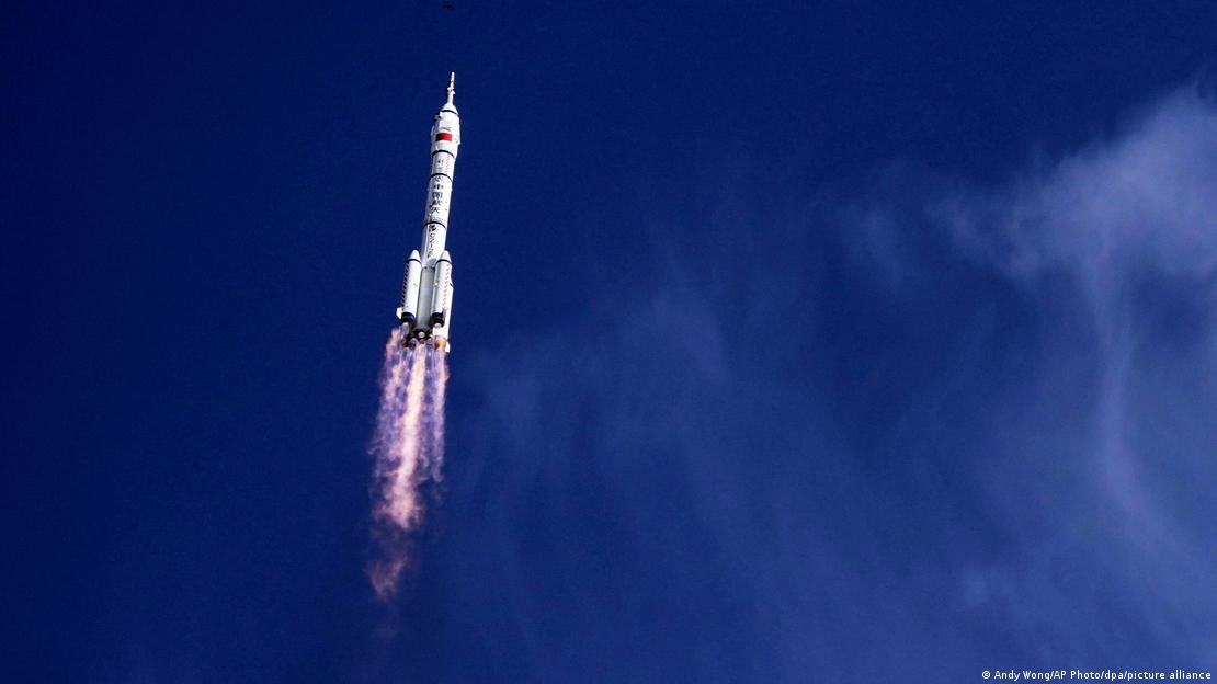 A rocket with a blast-off tail pointing upwards against an indigo sky