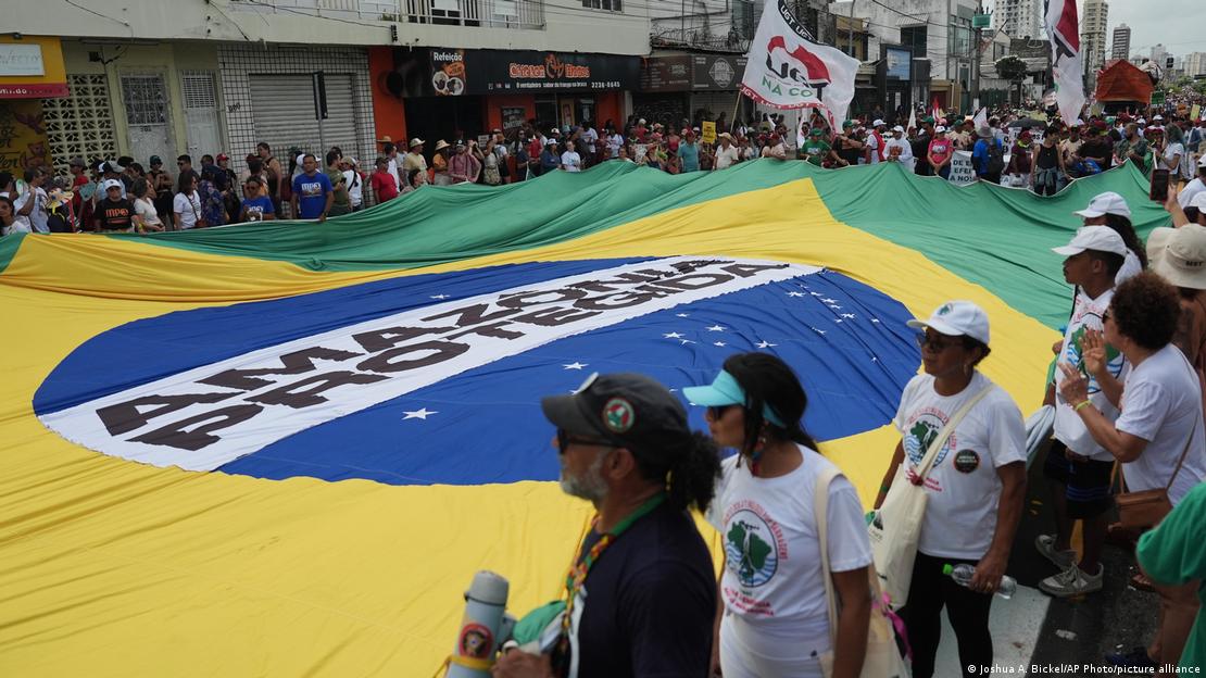 Activistas despliegan una gran bandera de Brasil en la que se lee 