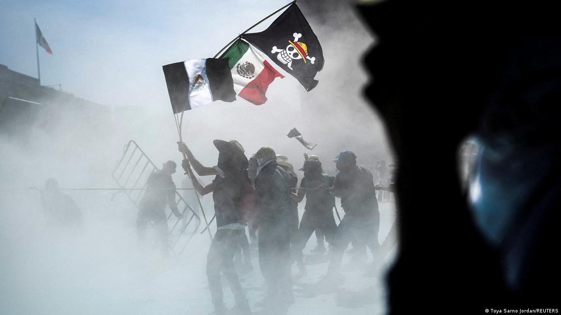 Manifestantes que se enfrentan a la Policía sostienen banderas de México y de One Piece.