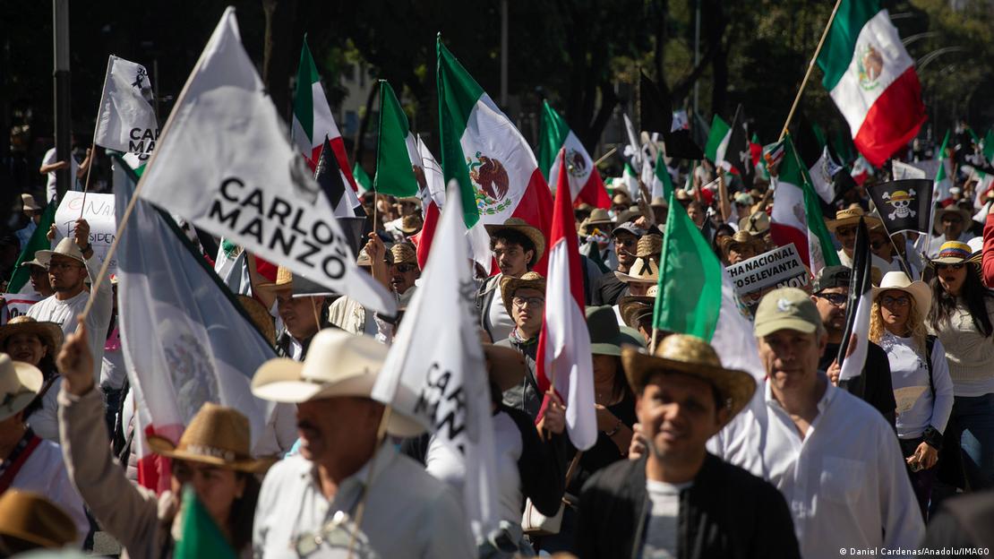 Göstericilerin elinde Carlos Manzo'nun adının yazılı olduğu bayraklar görülüyor