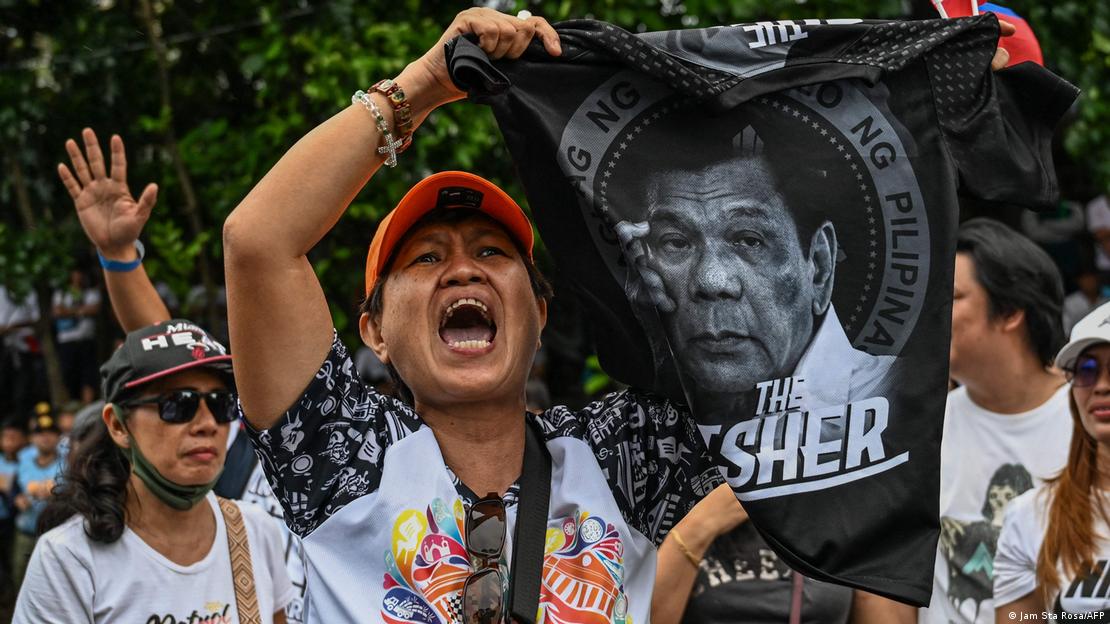 Una persona grita mientras sostiene un afiche con la foto del expresidente Duterte en Filipinas, durante protestas en su contra.