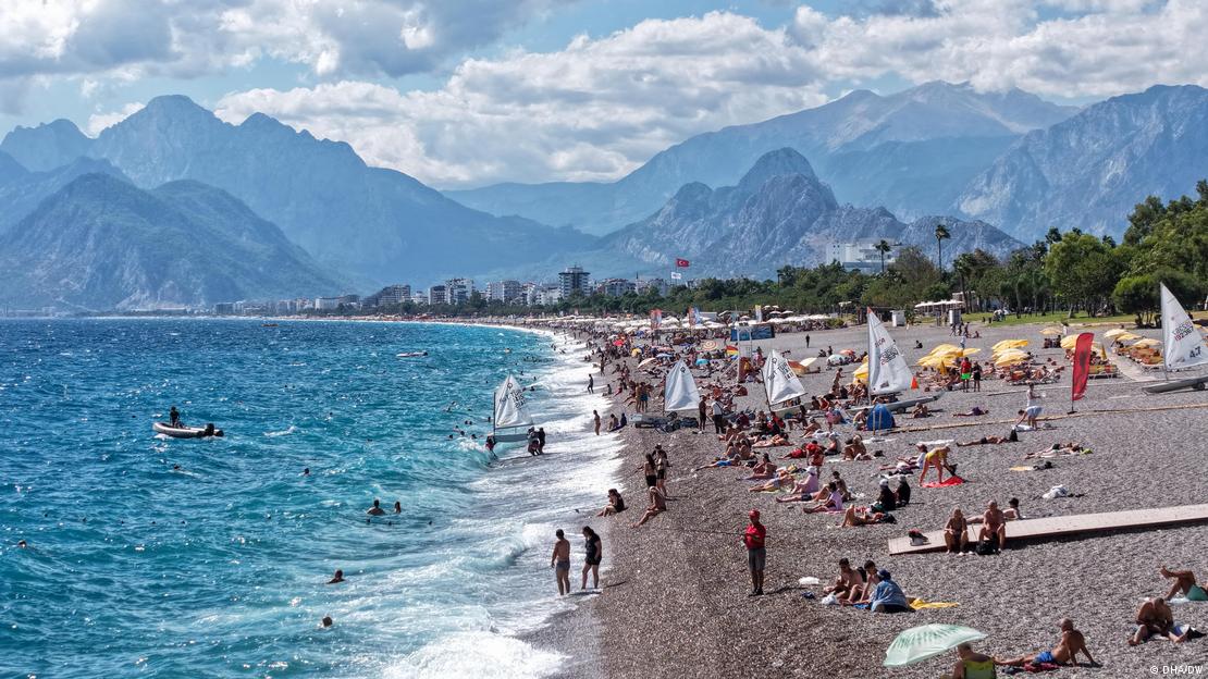 Bu yıl Ekim ayında Antalya'da deniz kenarında güneşlenenler ve denizde yüzenler
