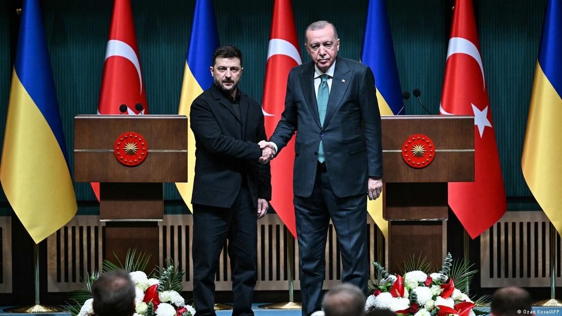 Presidentes da Ucrânia, Volodimir Zelenski, e da Turquia, Recep Tayyip Erdogan, se cumprimentam em frente a dois púlpitos e bandeiras de seus países