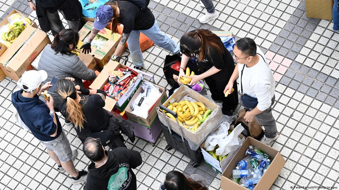 Voluntarios distribuyen alimentos y bebidas a los afectados por el incendio en el distrito de Tai Po, Hong Kong. (27.11.2025).