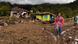 People walk past damaged houses at a village affected by flooding in Malalak, West Sumatra, Indonesia People walk past damaged houses at a village affected by flooding in Malalak, West Sumatra, Indonesia