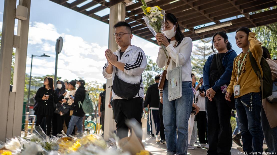 La gente se reúne para ofrecer flores tras la tragedia, en el distrito Tai Po