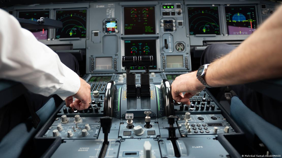 Bir A320'nin kokpiti. Görselde iki pilotun kolları görülüyor