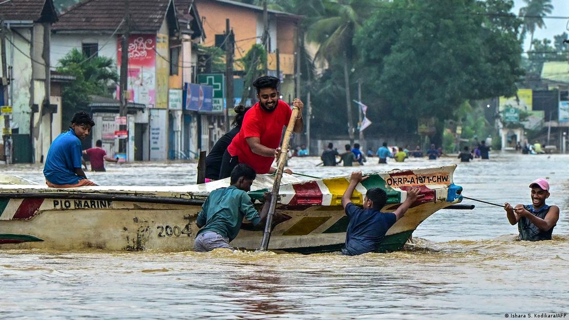 Sri Lanka'nın başkenti Colombo yakınlarındaki Kaduwela'da sular altında kalan sokaklarda bir botu çekerek ilerlemeye çalışan gönüllüler
